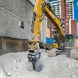 Cat rotary cutter being utilized by an excavator in an urban setting