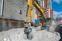 Cat rotary cutter being utilized by an excavator in an urban setting