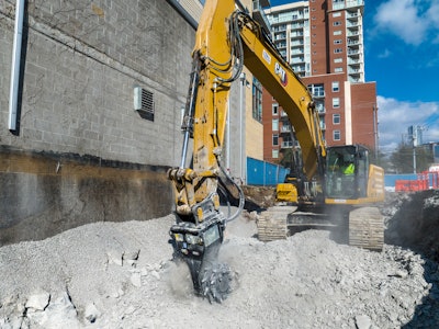 Cat rotary cutter being utilized by an excavator in an urban setting