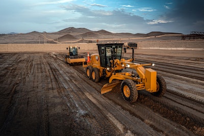 Cat 140 GC Motor Grader pushing dirt with compactor following