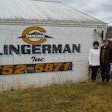 Kenny and Paula Clingerman beside white building with Clingerman Inc logo company name and photo number