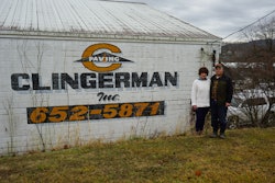 Kenny and Paula Clingerman beside white building with Clingerman Inc logo company name and photo number