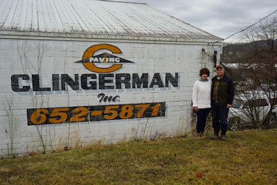 Kenny and Paula Clingerman beside white building with Clingerman Inc logo company name and photo number