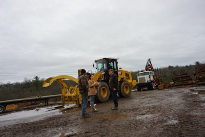 Clingerman family members talk by Cat wheel loader