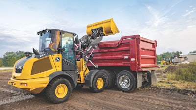 John Deere 244 P-Tier compact wheel loader dumping load.