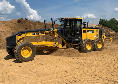 Komatsu GD655-7 motor grader pushing dirt beside dirt hill