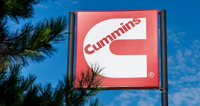 Cummins sign by pine tree top