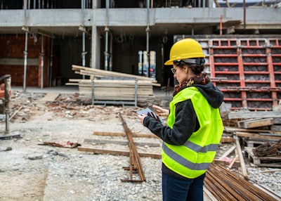 Worker looking at tablet on construction site