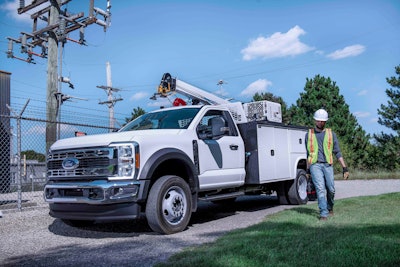 white 2023 Ford Super Duty F550 Chassis Cab with crane on top worker beside