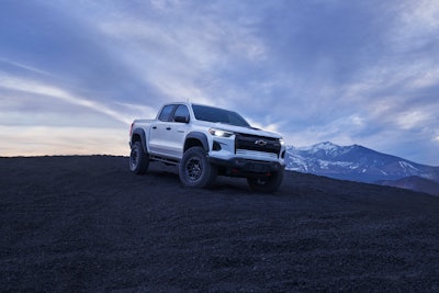 2024 Chevy Colorado ZR2 Bison on hilltop with mountains background grayish blue sky