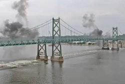 smoke rises after the old eastbound I-74 bridge over the Mississippi River between Illinois and Iowa is exploded