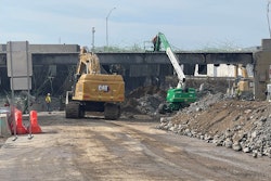 Cat excavator green white telehandler work on demolition of collapsed I-95 overpass Philadelphia