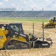 Deere compact track loader and bulldozer in an arena