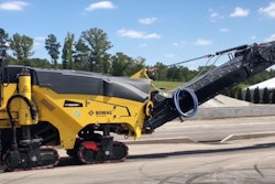 BOMAG BM 1200/35 cold planer dumping asphalt millings into back of dump truck