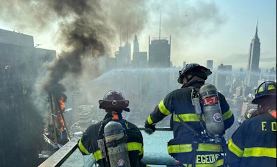 Firefighters work to put out a fire after a crane collapse in new york city