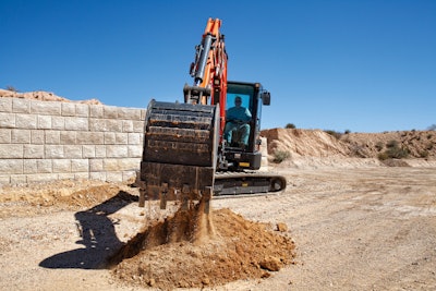 Develon DX42-7 compact excavator dumping dirt