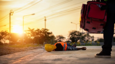 stock image worker lying on ground heat stroke first aid training
