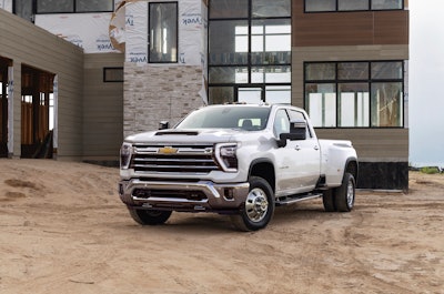 2024 Chevy Silverado 3500 parked in dirt area in front of building under construction
