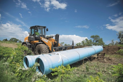 Case 721G wheel loader carrying pipes