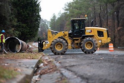 Cat 938 wheel loader approaching pipe with forks