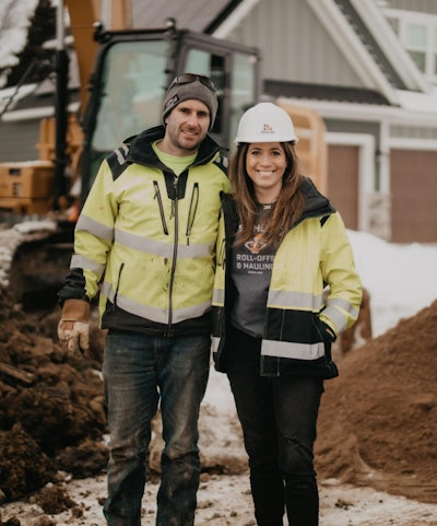 Missy & Trevor Scherber owners of T Scherber Demolition & Excavating on jobsite in front of excavator