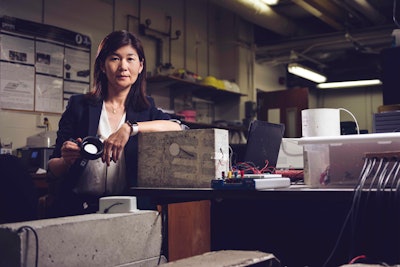 professor luna lu inventor of WaveLogix concrete sensor in lab holding sensor