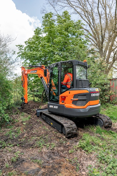 DEVELON DX63-7 compact excavator digging between trees