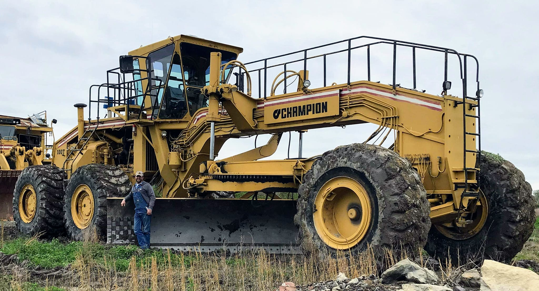 Garret Wilson beside huge Champion motor grader.