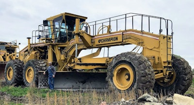 Garret Wilson beside huge Champion motor grader.