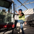 worker climbing into equipment cab