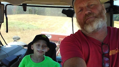 Roger Wenning with grandson Travis in tractor cab