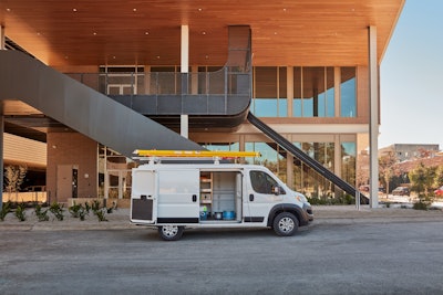 white 2024 Ram ProMaster ladder on top side door open parked in front of building