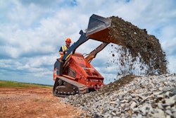 Ditch Witch SK1750 stand-on mini skid steer dumping rocks onto rock pile