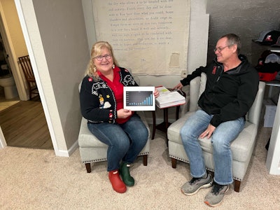 lillian callaway holds K&L industries annual revenue chart beside Keith Callaway Sr.