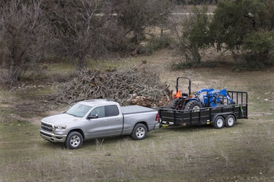 Ram 1500 Big Horn 2024 pickup truck towing blue tractor