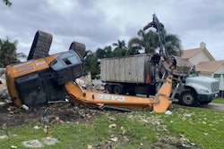 Case excavator overturned by debris pile bucket on top of crushed truck cab