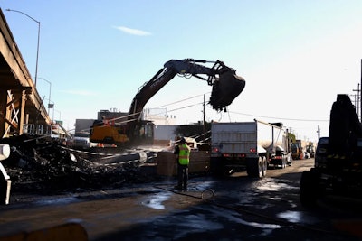 excavator cleans up fire aftermath under I-10 Freeway in L.A.
