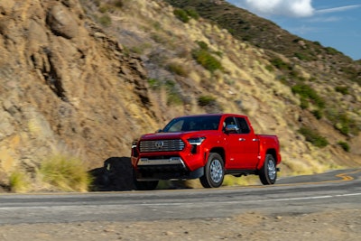 red 2024 Toyota Tacoma Limited driving on mountain road