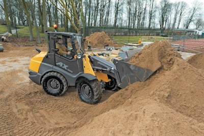MECALAC AX1000 compact wheel loader filling bucket with dirt