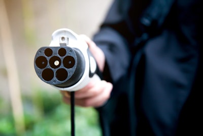 Man's hand holding an electric vehicle charger