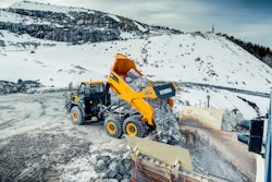 Hyundai HA45 articulated dump truck dumping rocks snowy mountains background