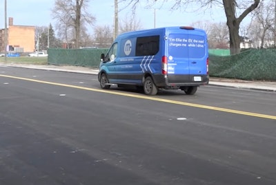 Blue Ford transit van wirelessly charged on EV charging road Detroit