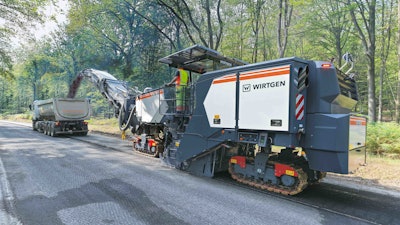 Wirtgen W220XFi cold planer dumping asphalt millings in truck bed