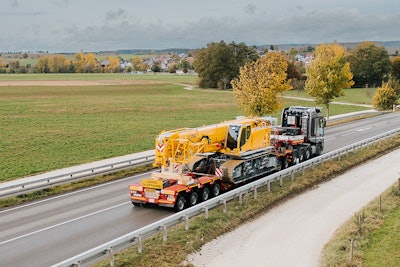 liebherr ltr 1150 crawler crane being towed down highway on trailer