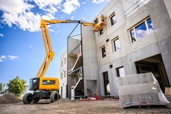 Haulotte HA46E electric rough terrain boom lift working on building construction