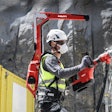 worker wearing Hilti EXO-T-22 tool balancer backpack drills into concrete column