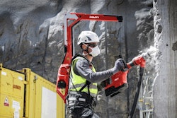 worker wearing Hilti EXO-T-22 tool balancer backpack drills into concrete column