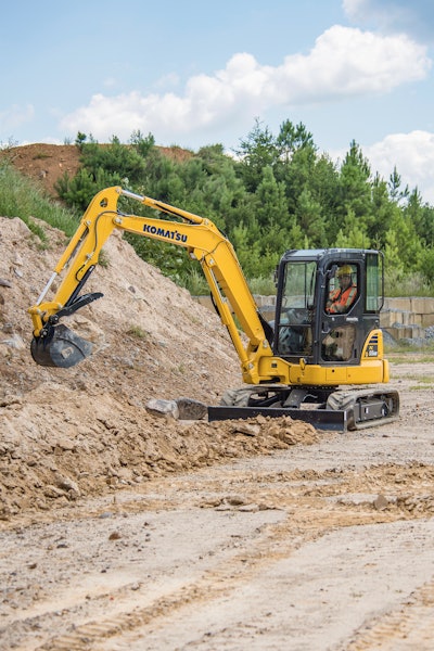 Komatsu PC55MR-5 mini excavator picks up rock