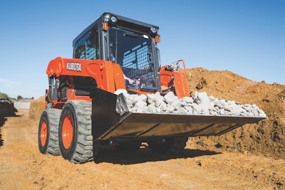 Kubota SSV75 skid steer carrying load of rocks