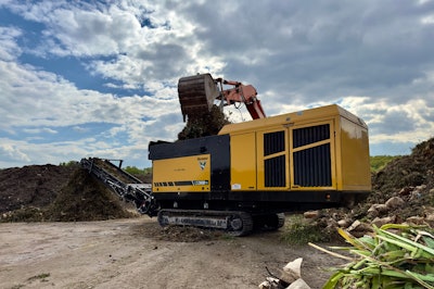 Excavator loading material into the Vermeer LS3600TX low speed shredder